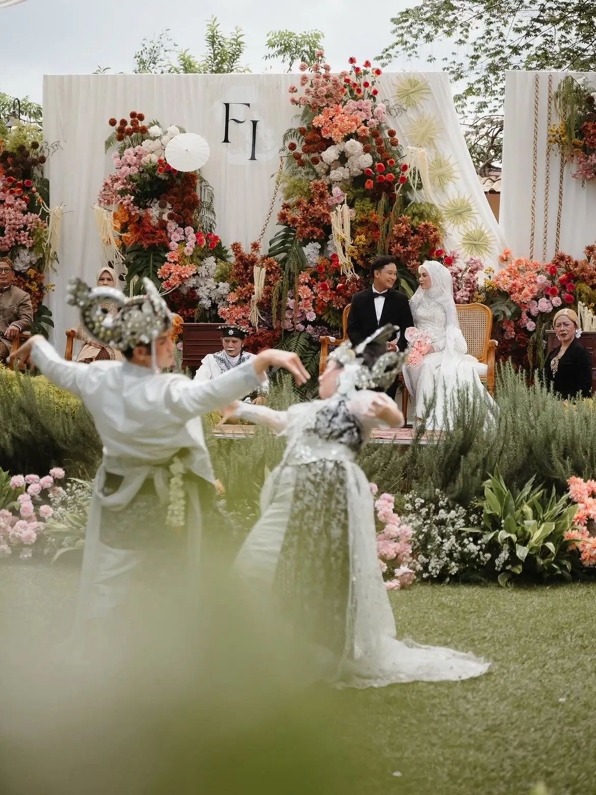 Traditional dancers performing in front of the couple at the floral stage