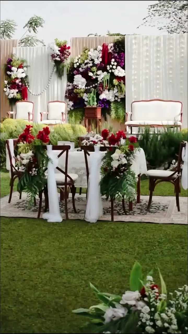A white and sage draped altar dressed with flowers on the lawn
